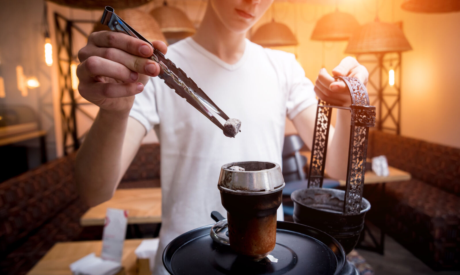 cooking hookah in the bar. young man with hookah in restaurant