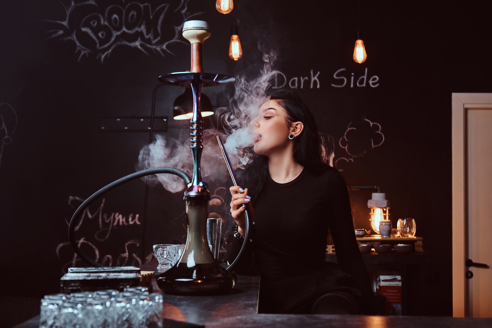 seductive brunette girl in black clothes in a hookah